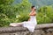 Beautiful ballet dancer in romantic dress sitting in the nature