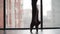 Beautiful ballet feet pointe shoes, the silhouette against the window and the city. Ballerina graceful gait. Slow motion. Close-up