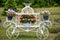 Beautiful Baskets of flowers Hanging Off White Chariot, Red Barn