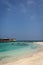 A beautiful bay inside a big resort in Maldives, green clear water with palm trees and blue sky