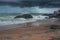 A beautiful beach, dark dramatic sky and rain