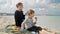 Beautiful beach day, a woman and her son happily enjoy a picnic, eating delicious apples by the sea