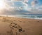 Beautiful beach with footprints in the sand. Couple of lovers walking on the beach at sunset and leaving foot prints on the beach.