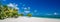 Beautiful beach panorama with palm trees and moody sky. Summer vacation travel holiday background concept. Maldives paradise beach