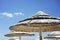 Beautiful beach resort with white straw umbrellas on a blue sky and white clouds. Beach life and lifestyle concept. Torre Lapillo