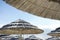 Beautiful beach resort with white straw umbrellas on a blue sky and white clouds. Beach life and lifestyle concept. Torre Lapillo