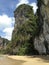 Beautiful beach, sheer cliffs, trees on the rock.