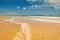 Beautiful beach with some bathe tourists in the distance. Holiday landscape. Edge of the sea