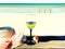 Beautiful beach with white  sand , glass of wine  on restaurant table , women hat with bow beachwear  and seashell   turquoise oc