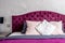 beautiful bed in elegant and comfortable modern bedroom with purple bedding. Interior design details