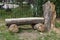 Beautiful bench with gray texture made of old fallen poplar tree with cracks is in summer day in the park