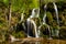 Beautiful Beusnita waterfall in the forest with green moss