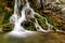 Beautiful Beusnita waterfall in the forest with green moss