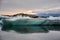 Beautiful big blue iceberg floating in Jokulsarlon glacial, Iceland in summer at dusk, reflecting in the water.