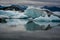Beautiful big blue iceberg floating in Jokulsarlon glacial, Iceland in summer at dusk, reflecting in the water.