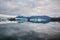 Beautiful big blue iceberg floating in Jokulsarlon glacial, Iceland in summer at dusk, reflecting in the water. Copy space