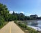 A beautiful bike and walking path along the ottawa river on a sunny summer day with blue sky.  The Supreme Court of Canada is back