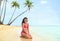 Beautiful bikini model on Tahiti luxury travel vacation island posing in red swimwear relaxing on sand. Asian woman