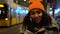 Beautiful biracial African American girl teenager young woman on urban city street at night talking on mobile cell phone