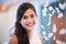 Beautiful biracial bride smiling next to curtain of white rose p