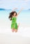 Beautiful biracial teen girl jumping in air on Hawaiian beach