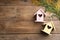 Beautiful bird houses with heart shaped holes and mimosa flowers on wooden background, space for text. Spring flat lay composition