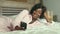 Beautiful black Afro American woman in pajamas lying relaxed smiling cheerful and fresh using internet mobile phone networking