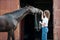 Beautiful black horse treats from young teenage girl`s hand