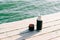 A beautiful black thermos of hot, herbal tea made from eco- friendly stainless steel stands on a wooden pier near the lake on a