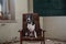 A beautiful black and white dog sits on a chair in an abandoned house. American Staffordshire Terrier.