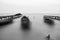 Beautiful black and white landscape with ghost boats on the lake anchored to the pier
