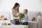 Beautiful blond boy, giving mother flowers and box with little gift for mothers day