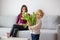 Beautiful blond boy, giving mother flowers and box with little gift for mothers day