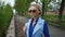 Beautiful blond business women wearing sunglasses blue suit waiting for meeting in the city at the river relax