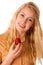 Beautiful blond cheerful caucasian woman eats a big red strawberrie isolated over white background