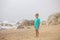 Beautiful blond child, boy, gathering shells on the beach in Portugal on a cloudy foggy day