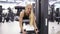 Beautiful blond female works out at reverse hypertension gym set. Building stong core. Working out glutes