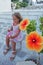 Beautiful blond girl of 3-4 years plays happy with flowers in Parikia, Paros, Greece
