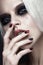 Beautiful blond girl with dark smokey makeup and art manicure design nails. beauty face.
