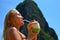 Beautiful blond girl enjoying coconut on the beach