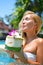 Beautiful blond girl enjoying coconut in the swimming pool