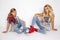 Beautiful blond girls, mother with daughter in jeans clothing on a white background in the studio.