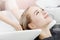 Beautiful blond woman getting hair wash in beauty salon. Concept head massage