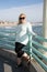 Beautiful blond woman poses on the Manhattan Beach California pier in the late afternoon sunshine. Full body portrait