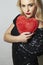 Beautiful Blond Woman with Red Heart. Beauty Girl. Show Love Symbol. Valentine\'s Day. Black Dress