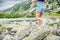 Beautiful blond woman is running in the mountains on rocks and stones.