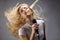 Beautiful blond woman singing into a microphone