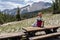 Beautiful blond woman sits on a picnic table at the Minaret Vista viewpoint in Mammoth Lakes California