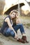 A beautiful blond woman sitting in sand in Chicago by Lake Michigan.