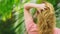 Beautiful blond woman touches her hair in nature. back view. hair treatment concept